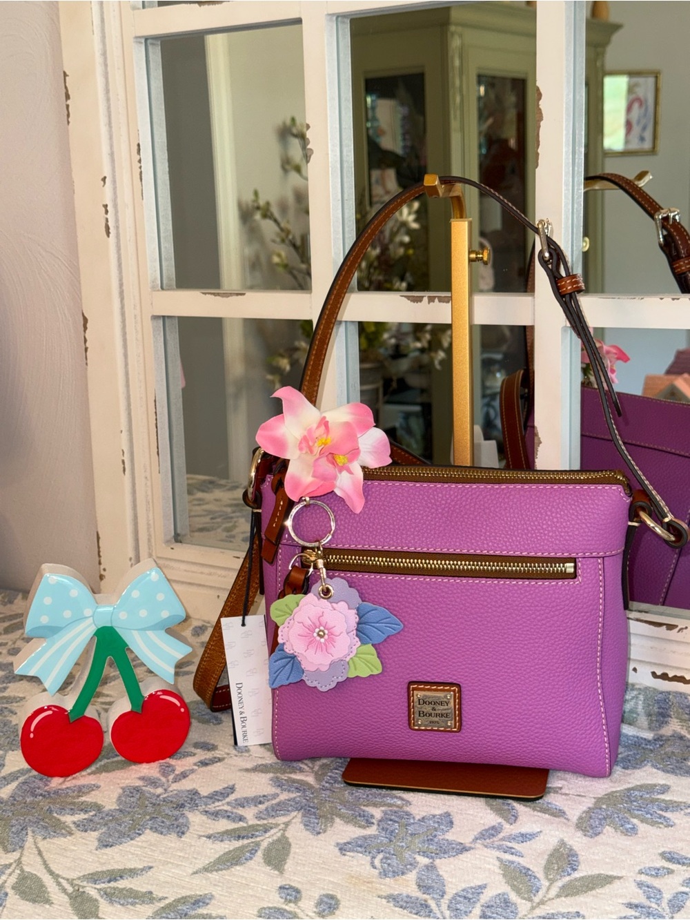 Dooney & Bourke Violet Pebbled Crossbody Bag with Floral Charm